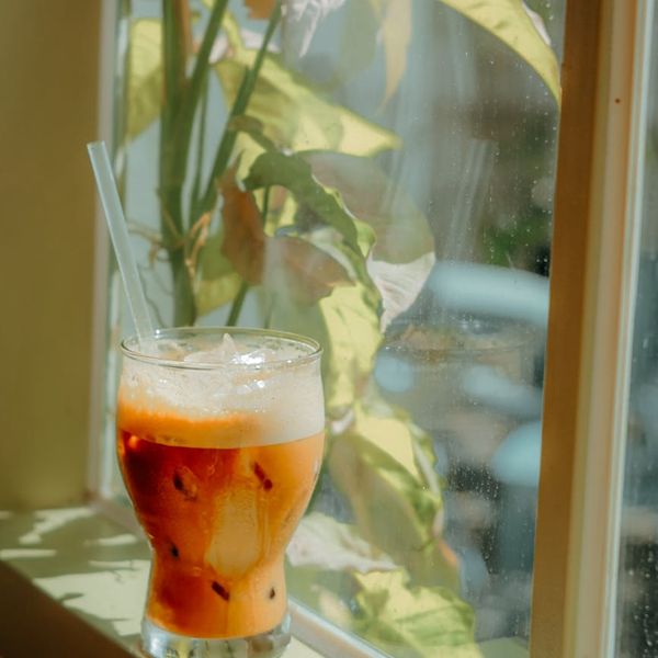 Person mindfully drinking tea by a window, integrating calm into daily life.